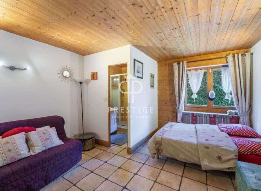 Cozy and inviting, this property boasts a charming interior with a warm wooden ceiling and tiled floors.