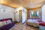 Cozy and inviting, this property boasts a charming interior with a warm wooden ceiling and tiled floors.
