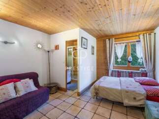Cozy and inviting, this property boasts a charming interior with a warm wooden ceiling and tiled floors.