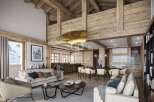 Experience luxury living in this stunning chalet, boasting a warm and inviting interior with exposed wooden beams and a cozy fireplace.