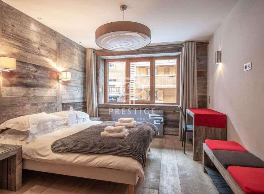Experience rustic charm in this cozy bedroom, featuring a stunning wooden accent wall and a comfortable bed.