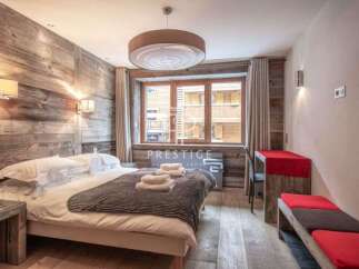 Experience rustic charm in this cozy bedroom, featuring a stunning wooden accent wall and a comfortable bed.