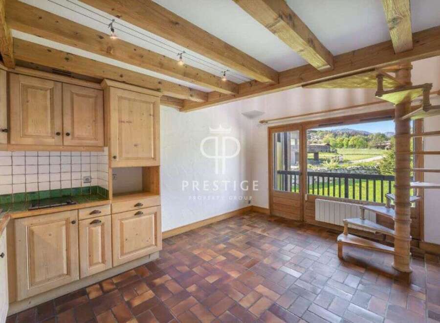 Discover a charming property with a rustic kitchen featuring wooden cabinets and a tiled backsplash.