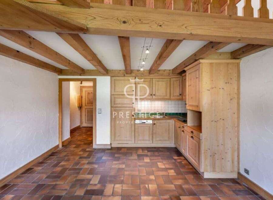 Discover the charm of this rustic kitchen, featuring exposed wooden beams and cabinetry.
