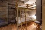 Discover the charm of this cozy bedroom featuring a unique wooden bunk bed, perfect for a comfortable stay.