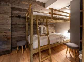 Discover the charm of this cozy bedroom featuring a unique wooden bunk bed, perfect for a comfortable stay.
