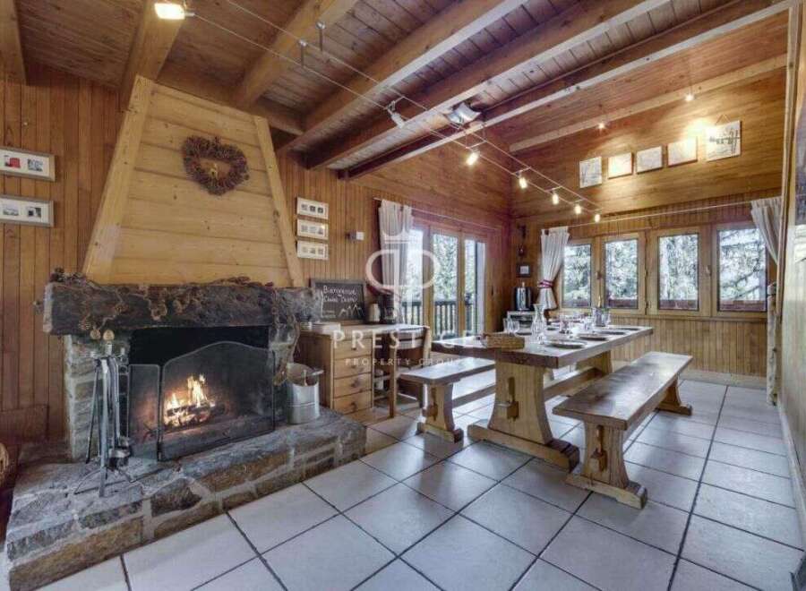Cozy up in this charming chalet! Featuring a rustic fireplace, wooden beams, and a dining area perfect for gatherings.