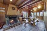 Cozy up in this charming chalet! Featuring a rustic fireplace, wooden beams, and a dining area perfect for gatherings.