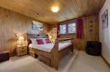 Cozy bedroom with wooden paneling and a warm ambiance.