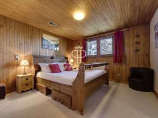 Cozy bedroom with wooden paneling and a warm ambiance.