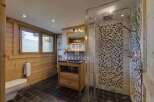 Discover the charm of this bathroom, featuring a stylish combination of wood and mosaic tiles.
