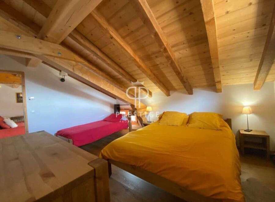 Discover the charm of this cozy bedroom with its wooden ceiling and inviting ambiance.