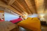 Discover the charm of this cozy bedroom with its wooden ceiling and inviting ambiance.