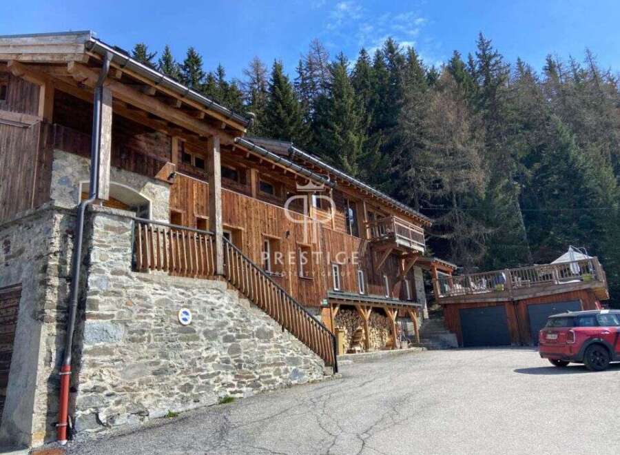 Discover a stunning wooden chalet nestled in a picturesque mountain setting.