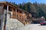 Discover a stunning wooden chalet nestled in a picturesque mountain setting.