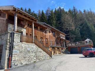 Discover a stunning wooden chalet nestled in a picturesque mountain setting.