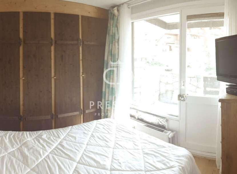 Cozy bedroom with a large wooden wardrobe and a comfortable bed.