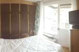 Cozy bedroom with a large wooden wardrobe and a comfortable bed.