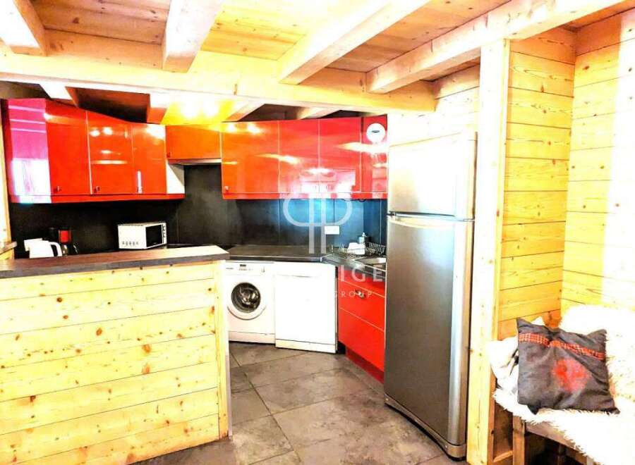 Discover this charming kitchen with its modern red cabinets and appliances.