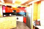 Discover this charming kitchen with its modern red cabinets and appliances.