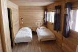 Cozy bedroom with wooden walls and floors, creating a warm and inviting atmosphere.