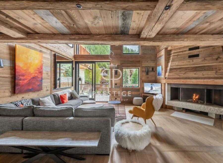 Experience luxury living in this stunning chalet, featuring a cozy fireplace and a spacious, modern living area.
