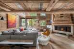Experience luxury living in this stunning chalet, featuring a cozy fireplace and a spacious, modern living area.