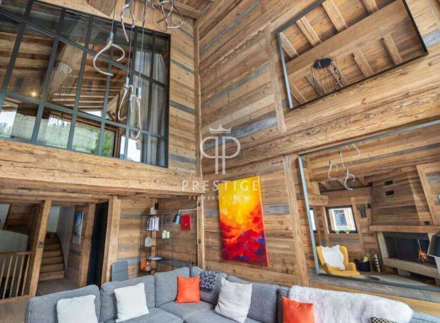 Experience luxury living in this stunning chalet, featuring a warm and inviting interior with exposed wooden beams.