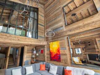 Experience luxury living in this stunning chalet, featuring a warm and inviting interior with exposed wooden beams.