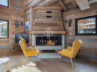 Experience luxury living in this stunning chalet, featuring a cozy fireplace and elegant yellow armchairs.