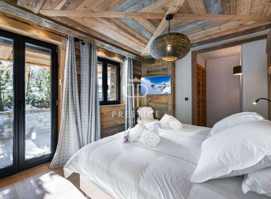 Experience luxury in this stunning bedroom featuring a cozy wooden ceiling and walls.