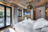 Experience luxury in this stunning bedroom featuring a cozy wooden ceiling and walls.