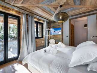 Experience luxury in this stunning bedroom featuring a cozy wooden ceiling and walls.