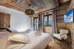 Experience luxury in this stunning bedroom featuring a rustic wooden ceiling and walls, creating a warm and inviting atmosphere.