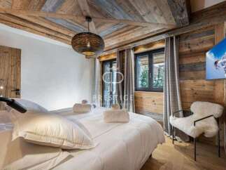 Experience luxury in this stunning bedroom featuring a rustic wooden ceiling and walls, creating a warm and inviting atmosphere.