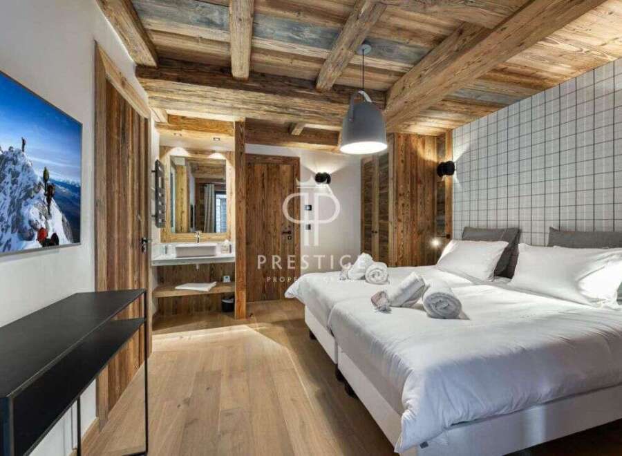 Experience luxury in this stunning property featuring a cozy bedroom with wooden accents and a modern design.