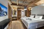 Experience luxury in this stunning property featuring a cozy bedroom with wooden accents and a modern design.