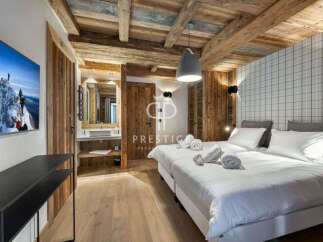 Experience luxury in this stunning property featuring a cozy bedroom with wooden accents and a modern design.