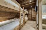 Experience rustic charm in this cozy bedroom featuring custom-built bunk beds.