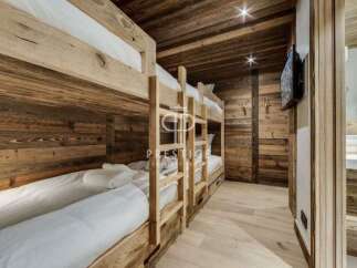 Experience rustic charm in this cozy bedroom featuring custom-built bunk beds.