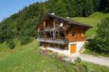 Discover a stunning wooden chalet nestled in a picturesque mountain setting.