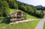 Discover a stunning wooden chalet nestled in a picturesque mountain setting.
