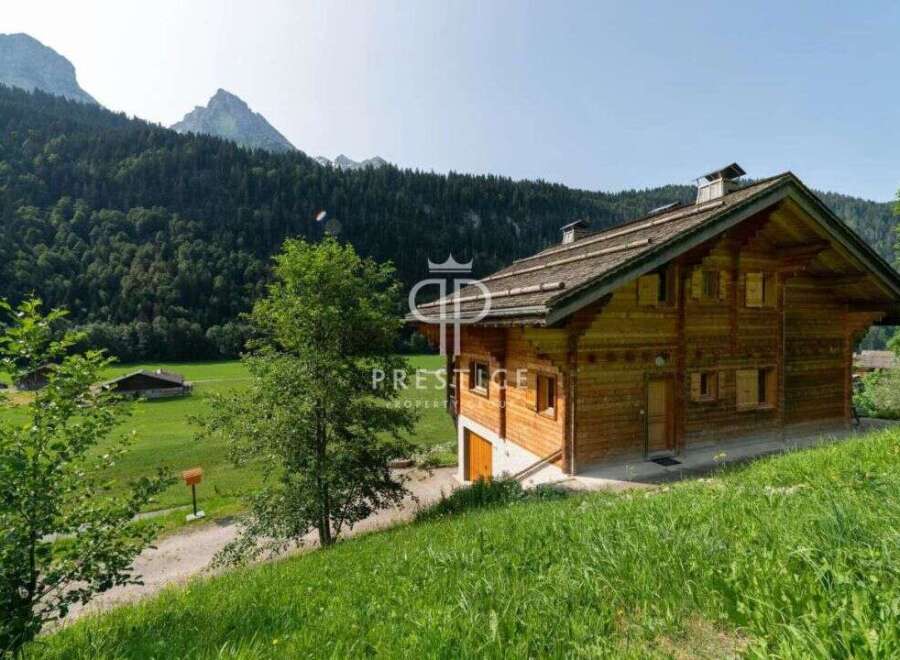 Discover a stunning wooden chalet nestled in a picturesque mountain setting.