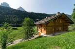 Discover a stunning wooden chalet nestled in a picturesque mountain setting.
