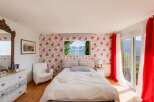 Discover the charm of this exquisite bedroom, featuring a stunning floral wallpaper that adds a touch of elegance.