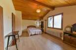Discover the charm of this inviting bedroom, featuring a cozy bed and a warm, wooden ceiling.