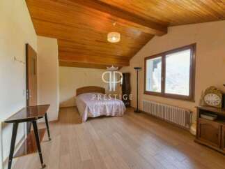 Discover the charm of this inviting bedroom, featuring a cozy bed and a warm, wooden ceiling.