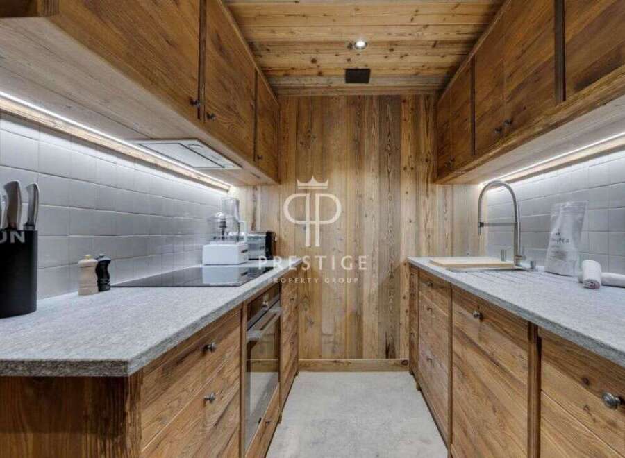 Experience the warmth of this stunning kitchen, featuring custom wooden cabinetry and a sleek countertop.
