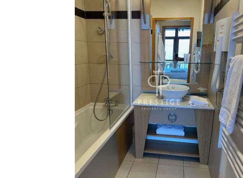 Discover a stylish bathroom featuring a sleek vanity and a modern bathtub.