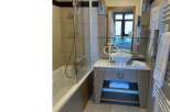 Discover a stylish bathroom featuring a sleek vanity and a modern bathtub.